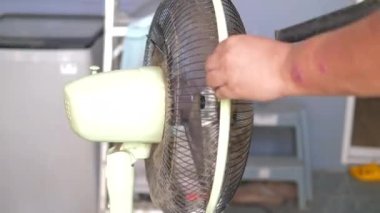 İnsanlar vantilatörü temizlemek için elektrikli süpürge kullanıyorlar. DIY ve ev bakımı kavramı