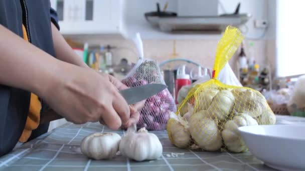 食品を調理するために準備するニンニクを剥がす女性 — ストック動画