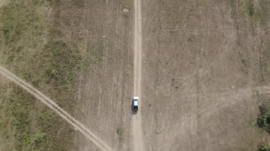 Drone 'un hava görüntüsü kurak mevsimde kırsal alanda terk edilmiş kamyonet yolu manzarası.