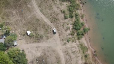 Drone 'un hava görüntüsü kurak mevsimde kırsal alanda terk edilmiş kamyonet yolu manzarası.