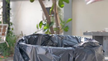 İnsanlar plastik su şişelerini ayıklayıp geri dönüşüm için atıkları ayırmak üzere çöpe atıyorlar.