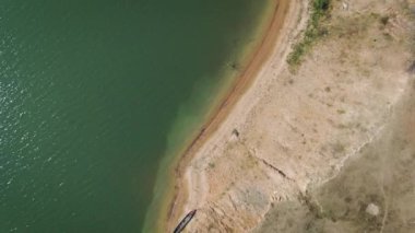 Drone, tropik kurak mevsimde sahili olan büyük bir nehri görüntüler.