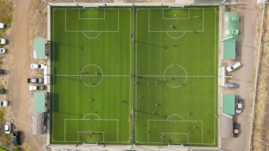 İnsansız hava aracı görüntüleri birçok insanın hava görüntüsü suni çim futbol sahasında spor yapıyor.