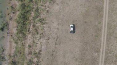 Drone 'un hava görüntüsü kurak mevsimde kırsal alanda terk edilmiş kamyonet yolu manzarası.