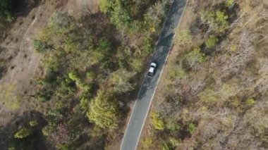 Drone 'un hava görüntüsü kurak mevsimdeki ıssız yolda arabayı sürüşün manzarası.