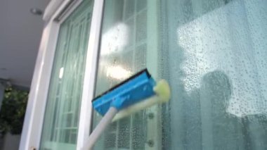 İnsanlar cam kapıyı temizliyor.