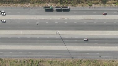 İnsansız hava aracı görüntüsü. Kırsal bölgedeki otobanda çok sayıda aracın trafiğinin manzarası.