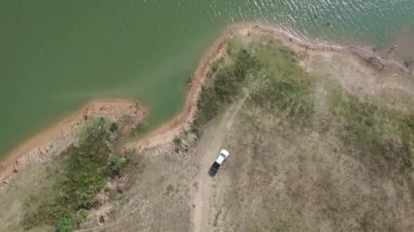 Drone görüntüleri Büyük nehrin yakınındaki kirli yollarda bir kamyonet sürüyor. 