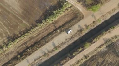 Drone 'un hava görüntüsü kurak mevsimde kırsal alanda terk edilmiş kamyonet yolu manzarası.