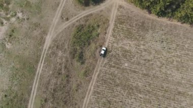 Drone 'un hava görüntüsü kurak mevsimde kırsal alanda terk edilmiş kamyonet yolu manzarası.