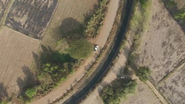 Drone 'un hava görüntüsü kurak mevsimde kırsal alanda terk edilmiş kamyonet yolu manzarası.