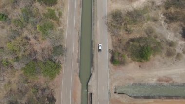 Drone 'un hava görüntüsü kurak mevsimde kırsal alanda terk edilmiş kamyonet yolu manzarası.