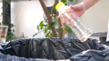 İnsanlar plastik su şişelerini ayıklayıp geri dönüşüm için atıkları ayırmak üzere çöpe atıyorlar.