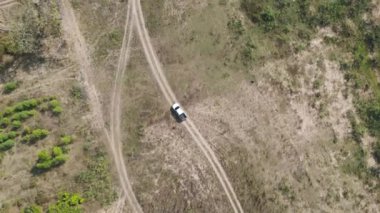 Drone 'un hava görüntüsü kurak mevsimde kırsal alanda terk edilmiş kamyonet yolu manzarası.