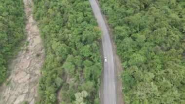 Drone 'un hava görüntüsü kurak mevsimde ıssız bir yolda araba sürüşünün manzarası.