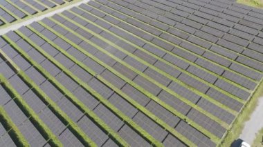Güneş çiftliğinin kırsal bölgelerdeki yavaş çekim drone görüntüleri. Güneş pilleri alanı temiz enerjiye alternatif bir enerji üretir. Düşük karbonlu elektrik gücü