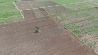 Bir traktörün tarlayı sürdüğü ve toprağı tarıma hazırladığı drone videosu.