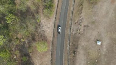 Drone 'un hava görüntüsü kurak mevsimde kırsal alanda terk edilmiş kamyonet yolu manzarası.