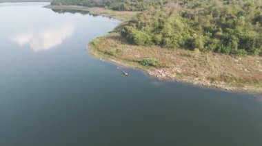 İHA görüntüleri, geniş bir nehirde yüzen teknenin manzaralı manzarası.