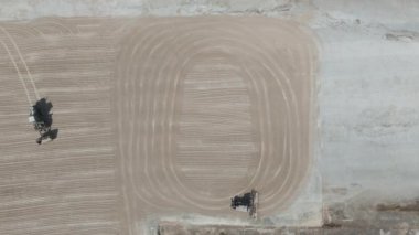 İnsansız hava aracı görüntüleri bir traktör cassava kurutma sahasına cassava yayıyor.