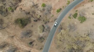 Drone 'un hava görüntüsü kurak mevsimde ıssız bir yerde araba sürerken çekilmiş manzarası.