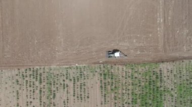 Bir traktörün tarlayı sürdüğü ve toprağı tarıma hazırladığı drone videosu.
