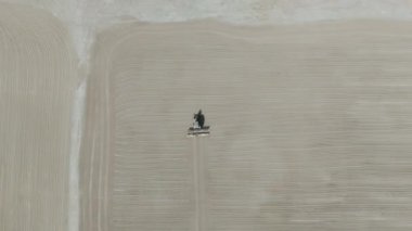 Drone videosu bir traktör cassava kurutma sahasına cassava yayıyor. Cassava un hazırlama süreci