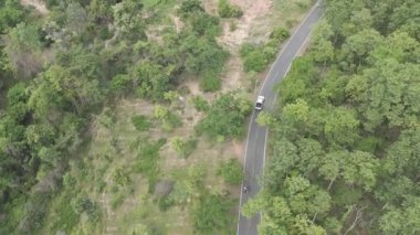 Drone 'un hava görüntüsü kamyonet sürüşünün manzarası kırsal kesimdeki ıssız bir yolda kurak mevsim.