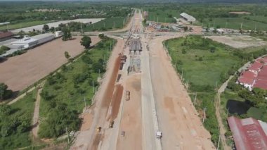 Vinç işçileri, traktörler ve kepçeler tarafından kavşağın üzerine beton köprü inşa edilmeden önceki inşaat alanı.