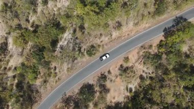 İnsansız hava aracı görüntüleri kırsal kesimde kurak mevsimde terk edilmiş bir yolda kamyonet sürerken görüntüler.