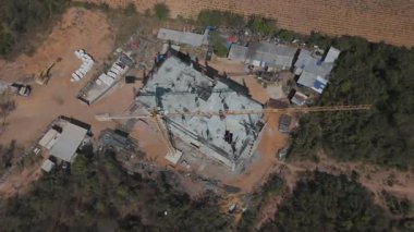 Vinç ve işçilerin inşa ettiği yüksek katlı beton bina inşaat alanının manzaralı insansız hava aracı görüntüleri.
