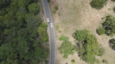 İnsansız hava aracı görüntüleri kırsal kesimde kurak mevsimde terk edilmiş bir yolda kamyonet sürerken görüntüler.