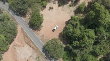 İnsansız hava aracı görüntüleri kırsal kesimde kurak mevsimde terk edilmiş bir yolda kamyonet sürerken görüntüler.