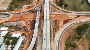 Tayland 'daki inşaat alanının insansız hava aracı görüntüleri. Vinç işçileri, traktörler ve kepçelerle kavşağın üzerindeki beton köprü.