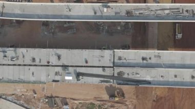 Otoyol üstgeçit inşaatı, makineler, kamyonlar ve altyapı gelişimi ile ilgili insansız hava aracı görüntüleri. İnşaat mühendisliği ve ulaşım projeleri kavramı