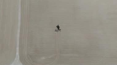 Drone videosu bir traktör cassava kurutma sahasına cassava yayıyor. Cassava un hazırlama süreci