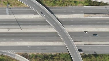 Kırsal kesimde tarlaları ve yolları olan otobandaki araçların insansız hava görüntüsü. Altyapı, lojistik veya ulaşım konsepti için ideal