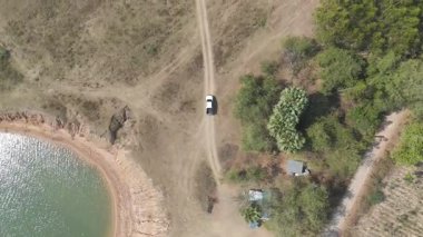 Drone 'un hava görüntüsü kurak mevsimde kırsal alanda terk edilmiş kamyonet yolu manzarası.