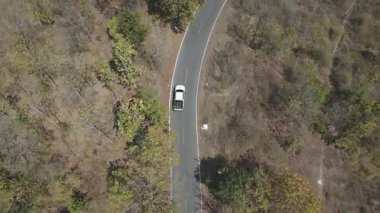 Drone 'un hava görüntüsü kurak mevsimde kırsal alanda terk edilmiş kamyonet yolu manzarası.