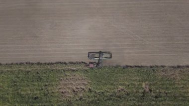 Traktörlerin ve kamyonların şeker kamışını şeker yapmak için çiftlikte topladıkları drone görüntüleri. Yanmadan çiftçilik yapmak