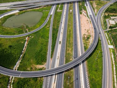 Drone, Tayland 'da yeşil tarlaların üzerinden geçen büyük bir otoyol kavşağını vurdu. Katmanlı yollar ve rampalar kırsal bir yerdeki modern ulaşım altyapısını vurguluyor