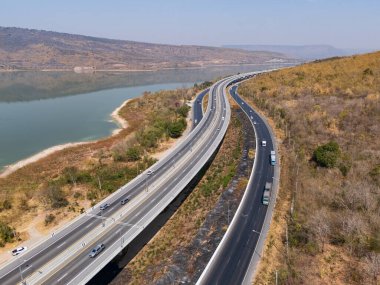 İnsansız hava aracı, M6 otoyolu Nakhon Ratchasima Eyaleti 'ni vurdu. Lam Ta Khong Nehri ve Dağı. Manzaranın insansız hava aracı görüntüsü kırsal bölge trafiği. Nakhon Ratchasima Tayland. Kora Otoyolu