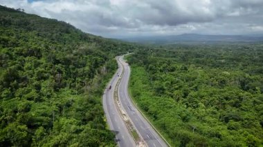Uçağı, yemyeşil ormanı kesen dolambaçlı bir yola bakıyor. Tayland 'da 304 numaralı otoyol Bangkok bölgesini kuzeydoğu bölgesindeki Nakhon Ratchasima' ya bağlıyor.