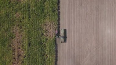 Traktörlerin ve kamyonların şeker kamışını şeker yapmak için çiftlikte topladıkları drone görüntüleri. Yanmadan çiftçilik yapmak