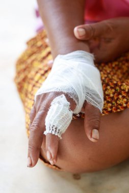 Yaralı ve bandajlı yaşlı bir kadının eli.