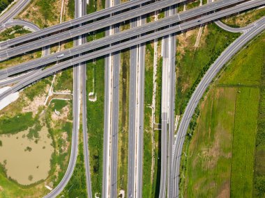 Drone, Tayland 'da yeşil tarlaların üzerinden geçen büyük bir otoyol kavşağını vurdu. Katmanlı yollar ve rampalar kırsal bir yerdeki modern ulaşım altyapısını vurguluyor