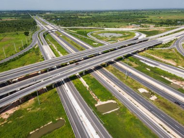 Drone, Tayland 'da yeşil tarlaların üzerinden geçen büyük bir otoyol kavşağını vurdu. Katmanlı yollar ve rampalar kırsal bir yerdeki modern ulaşım altyapısını vurguluyor