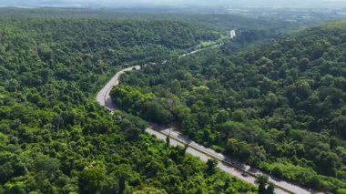Uçağı, yemyeşil ormanı kesen dolambaçlı bir yola bakıyor. Tayland 'da 304 numaralı otoyol Bangkok bölgesini kuzeydoğu bölgesindeki Nakhon Ratchasima' ya bağlıyor.