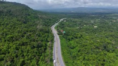 Uçağı, yemyeşil ormanı kesen dolambaçlı bir yola bakıyor. Tayland 'da 304 numaralı otoyol Bangkok bölgesini kuzeydoğu bölgesindeki Nakhon Ratchasima' ya bağlıyor.