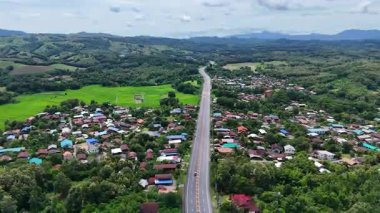 Nan, Tayland 'daki yemyeşil dağların arasından geçen otobanın havadan görünüşü, tropikal ormanlar ve huzurlu kırsal bölgelerle çevrili manzaralı bir yol gösteriyor. İnsansız hava aracı görüntüleri